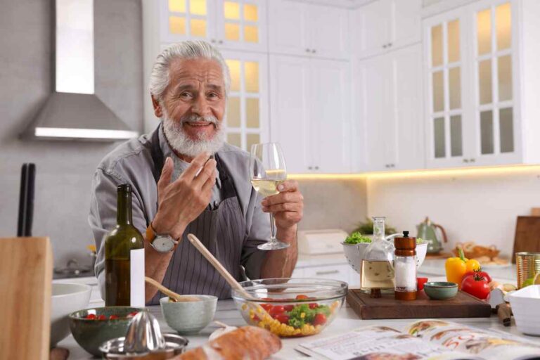anziano davanti a cibo e bicchiere di vino