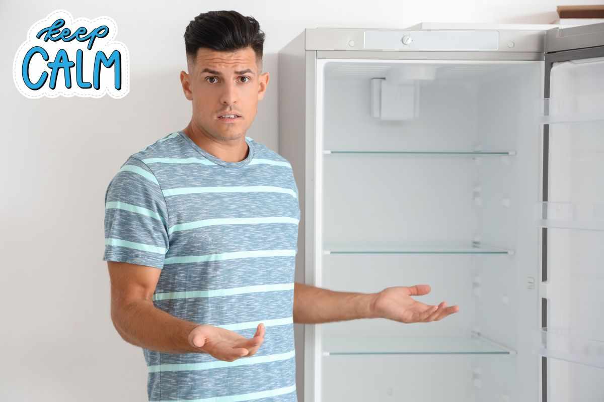 Uomo davanti a frigo vuoto 