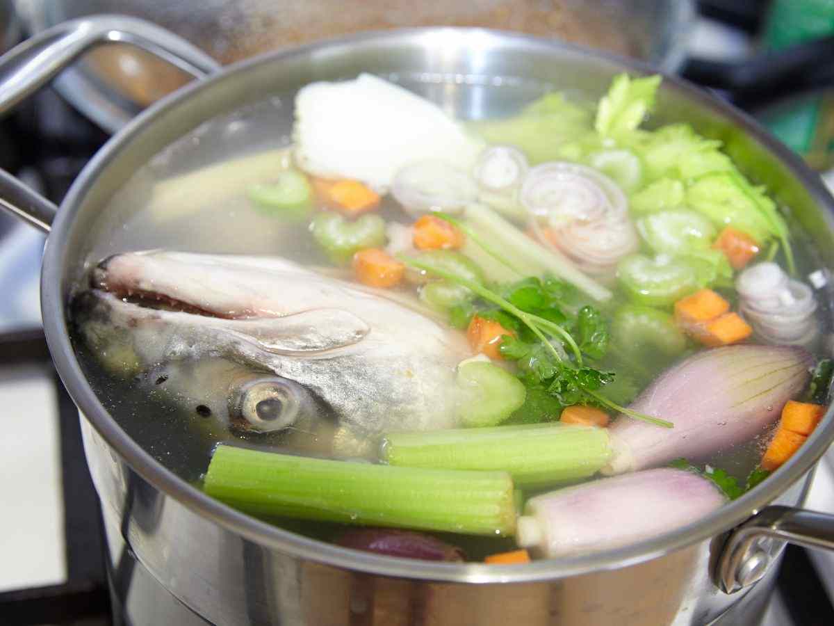 pentola con brodo di pesce e verdure
