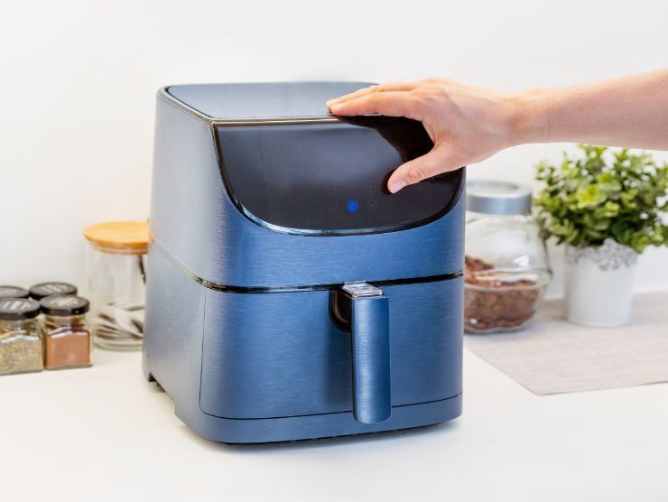 mano che accende friggitrice ad aria