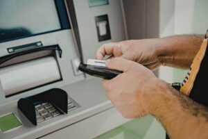 uomo preleva al bancomat