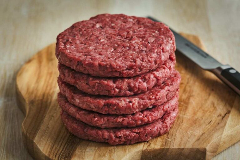 pila di hamburger sistemati su un tagliere